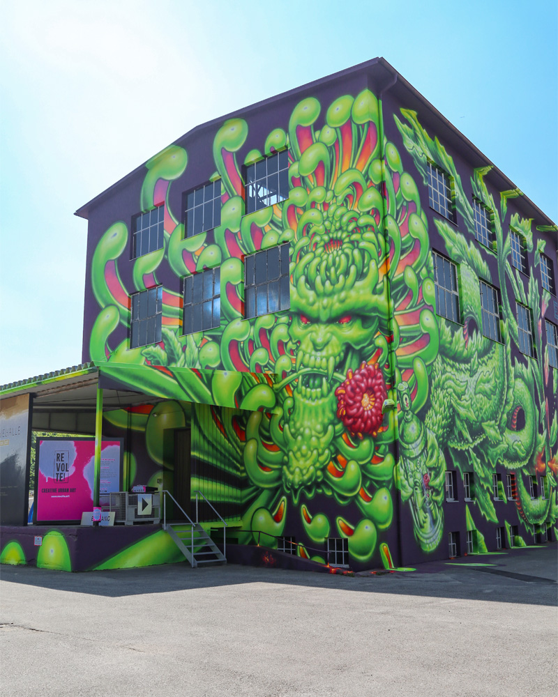 Revolte Außenansicht Kreativraum Atelier Türke Großflächiges Graffiti bedeckt die Fassade des Schwelhalle von Atelier Türke mit intensiven Farben und detailreichen Motiven und zeigt die eindrucksvolle urbane Gestaltung des Projekts Revolte von Atelier Türke.