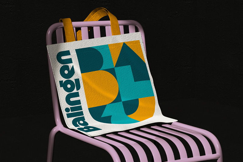 Balingen Logo Design Merch Atelier Türke Stofftasche mit geometrischem Design und Schriftzug Balingen auf einem Stuhl, gestaltet von Atelier Türke für eine prägnante und moderne Markenkommunikation.